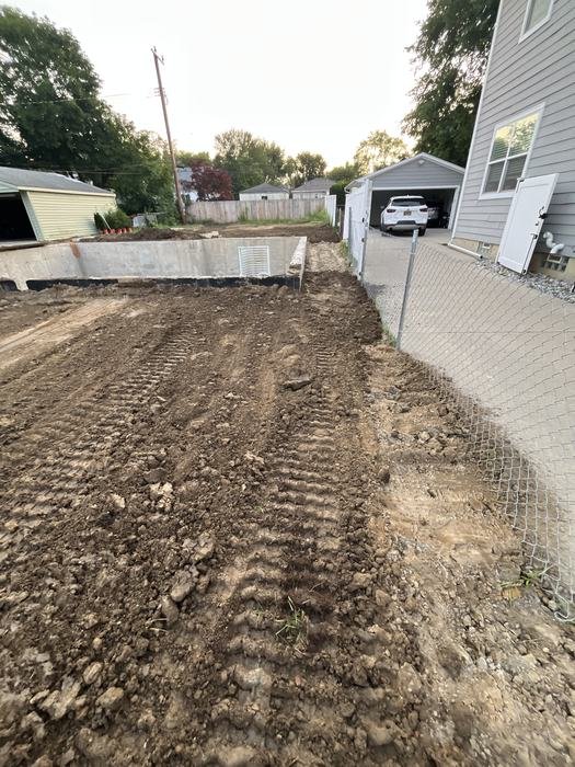 Graded site access alongside the neighboring home during foundation work