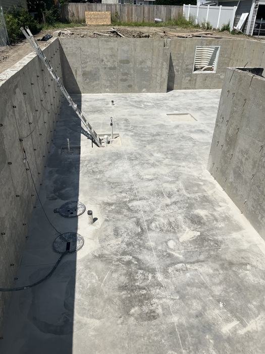 Finished concrete basement slab inside the poured foundation walls of a new home